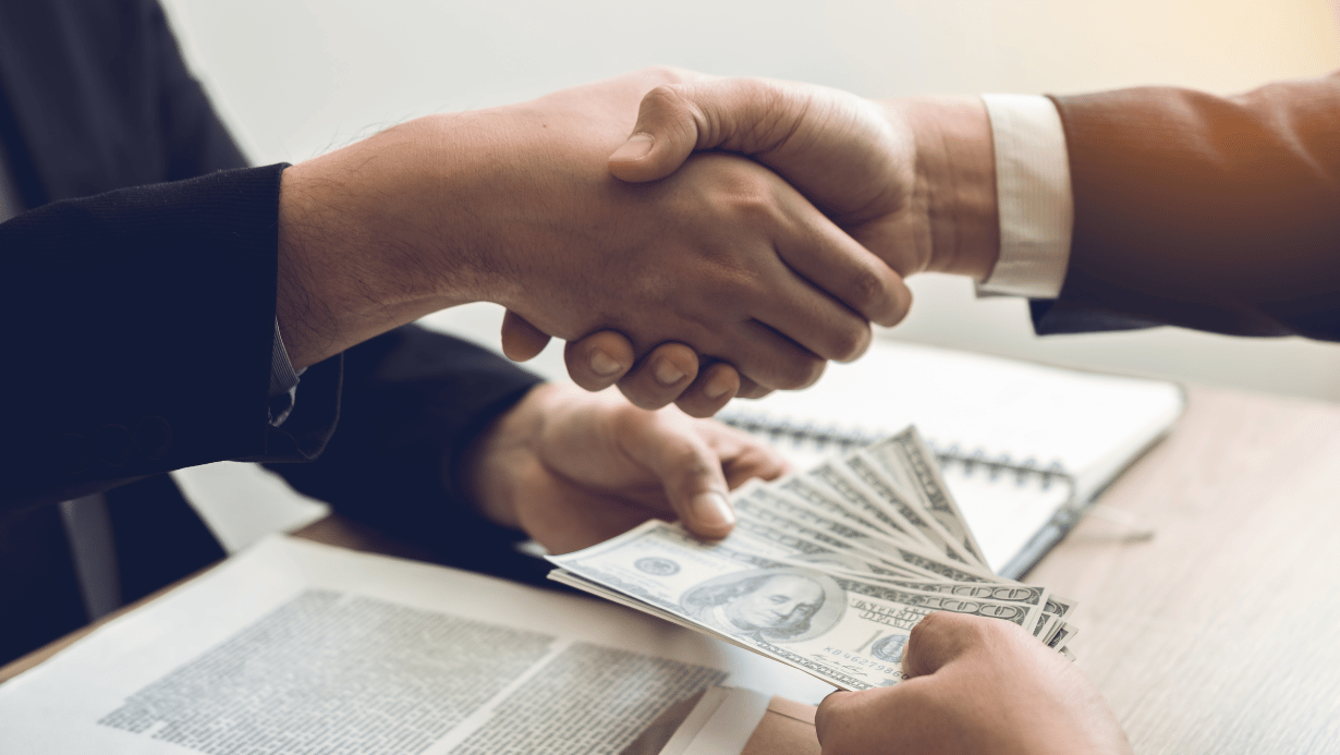 Businessmen Shaking Hands and Receiving Money